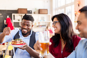 Image showing happy friends eating at restaurant