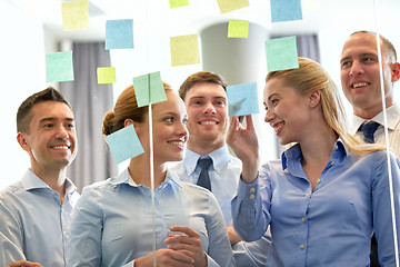 Image showing business team at glass wall with sticky notes