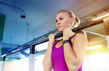 Image showing woman exercising and doing pull-ups in gym