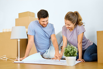 Image showing couple with boxes and blueprint moving to new home