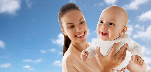 Image showing happy mother playing with little baby boy over sky