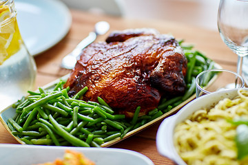 Image showing roast chicken with garnish of green peas on table