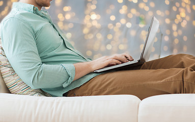 Image showing close up of man working with laptop over lights