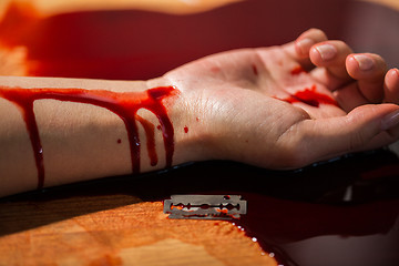 Image showing dead woman hand in blood on floor at crime scene