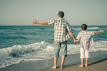 Image showing Father and son playing on the beach at the day time.