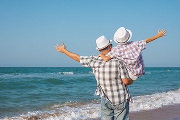 Image showing Father and son playing on the beach at the day time.