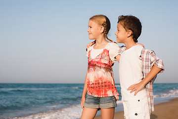 Image showing Two happy little children playing on the beach at the day time.