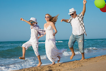 Image showing Father mother and  son  playing on the beach at the day time.