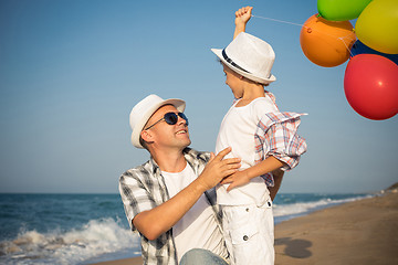 Image showing Father and son playing on the beach at the day time.