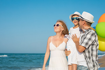 Image showing Father mother and  son  playing on the beach at the day time.