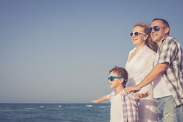 Image showing Father mother and  son  playing on the beach at the day time.