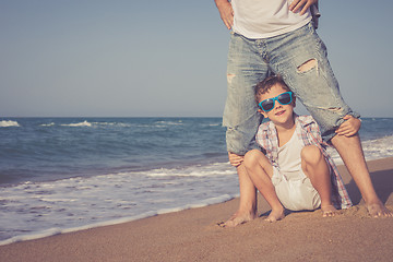 Image showing Father and son playing on the beach at the day time.