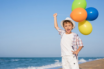 Image showing One happy little boy playing on the beach at the day time. 