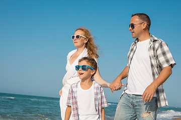 Image showing Father mother and  son  playing on the beach at the day time.