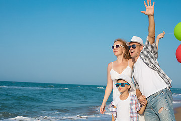 Image showing Father mother and  son  playing on the beach at the day time.