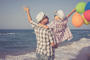 Image showing Father and son playing on the beach at the day time.