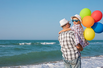 Image showing Father and son playing on the beach at the day time.