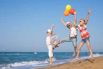 Image showing Father and son and daughter playing on the beach at the day time