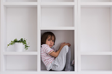 Image showing young boy posing on a shelf