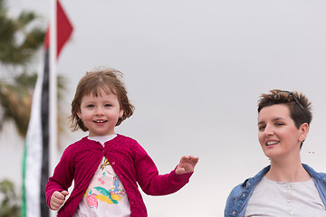 Image showing mother and cute little girl on the promenade by the sea