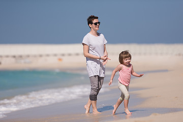 Image showing mother and daughter running on the beach