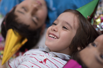 Image showing kids  blowing confetti while lying on the floor