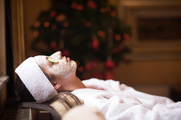 Image showing woman is getting facial clay mask at spa