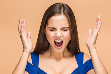 Image showing Frustrated young woman screaming at studio