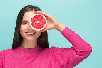 Image showing Pretty woman with delicious grapefruit in her arms.