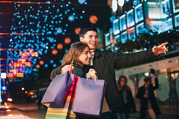 Image showing The happy couple with shopping bags enjoying night at city background