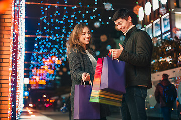 Image showing The happy couple with shopping bags enjoying night at city background