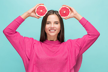 Image showing Pretty woman with delicious grapefruit in her arms.