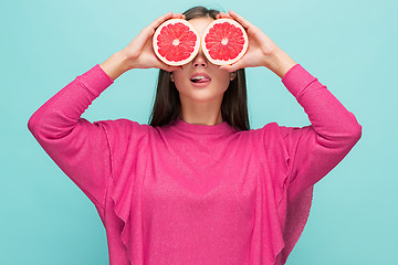 Image showing Pretty woman with delicious grapefruit in her arms.