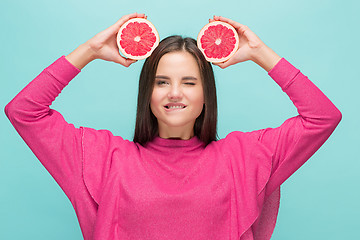 Image showing Pretty woman with delicious grapefruit in her arms.