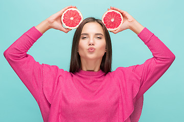 Image showing Pretty woman with delicious grapefruit in her arms.