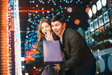 Image showing The happy couple with shopping bags enjoying night at city background