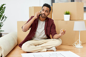 Image showing man with blueprint and boxes moving to new home