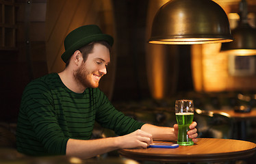 Image showing man with smartphone and green beer at bar or pub
