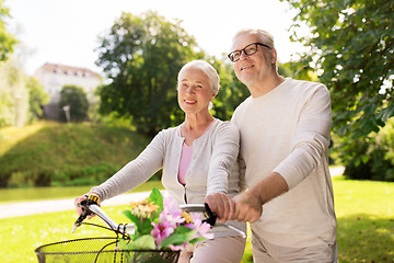 Image showing happy senior couple with bicycles at summer park