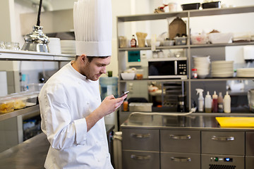 Image showing chef cook with smartphone at restaurant kitchen