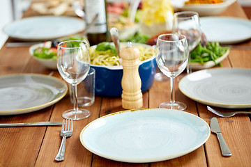 Image showing table served with plates, wine glasses and food