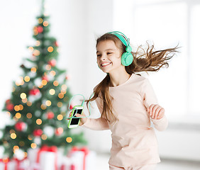 Image showing girl with smartphone and headphones at christmas