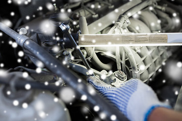 Image showing mechanic hand with wrench and lamp repairing car