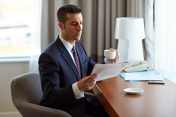 Image showing businessman reading newspaper and drinking coffee