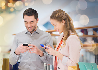 Image showing couple with smartphones and shopping bags in mall