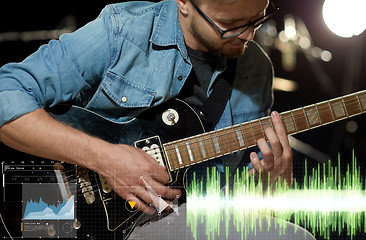 Image showing close up of musician playing guitar at studio