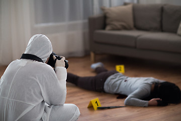 Image showing criminalist photographing dead body at crime scene