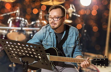 Image showing musician playing guitar at studio over lights