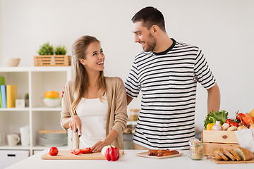 Image showing happy couple cooking food at home kitchen