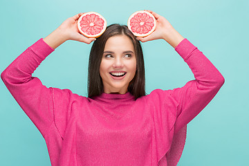 Image showing Pretty woman with delicious grapefruit in her arms.